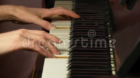 两只女手在一架漂亮的大钢琴上演奏一首轻柔的古典音乐弹钢琴的女人特写视频的预览图