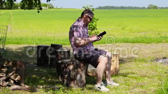 夏天男人在树下使用平板电脑视频的预览图