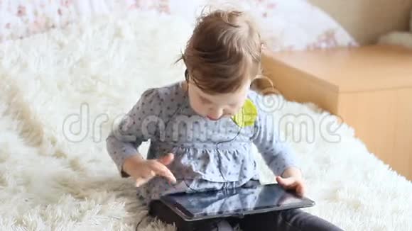 有趣的快乐孩子手拿平板电脑戴着耳机视频的预览图