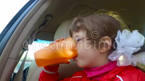 小女孩在车里喝果汁女孩吃完了雨停了视频的预览图