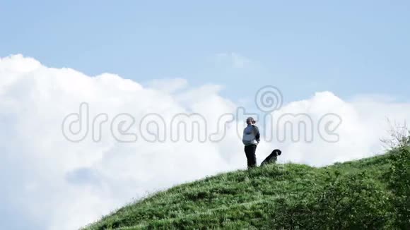 有条狗站在山坡上的女人视频的预览图