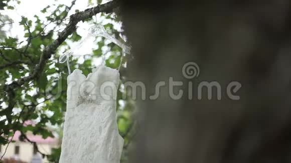 白色婚纱挂在城堡附近的一棵树上视频的预览图
