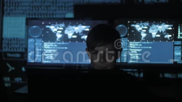 可爱的少年程序员在数据中心的一台电脑上工作里面装满了显示屏神童画像视频的预览图
