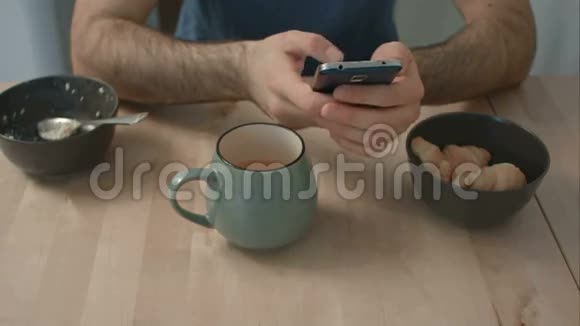 男人早餐桌上拿着电话视频的预览图