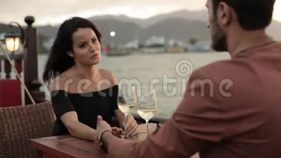 年轻漂亮的夫妇一起坐在游船甲板上端着酒杯视频的预览图