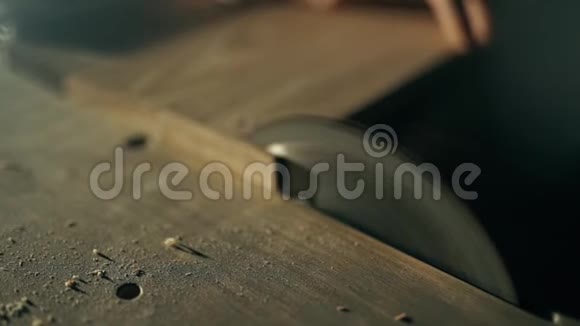 一个人正在用圆锯锯一块木头视频的预览图