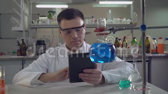英俊的成人化学家进入结果实验视频的预览图