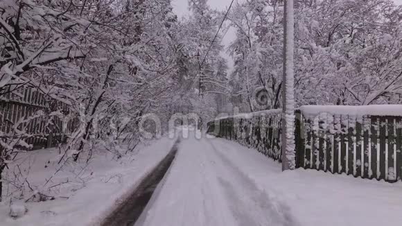 村里的冬季道路雪瀑布视频的预览图