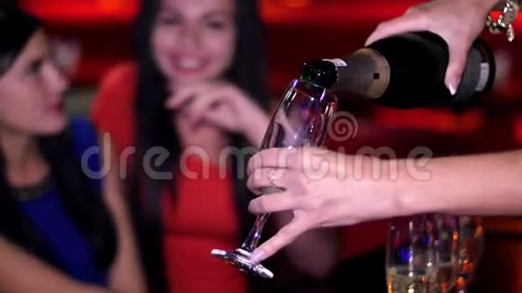 晚会上漂亮的女孩把香槟倒进酒杯里视频的预览图
