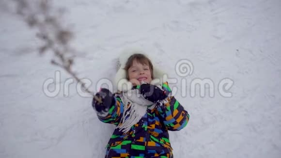 冬天公园里一个非常可爱快乐的小男孩冬天的时候快乐的男孩在雪地公园玩得开心他很高兴视频的预览图