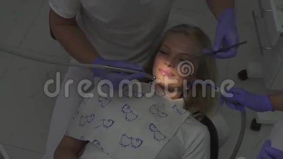 坐在牙医椅子上的漂亮女孩笑容灿烂牙科卫生程序视频的预览图