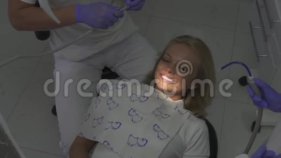 牙科医生的病人坐在牙医的椅子上笑容灿烂的美丽女孩视频的预览图