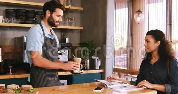 服务员在餐桌上给顾客端上一杯冷咖啡视频的预览图