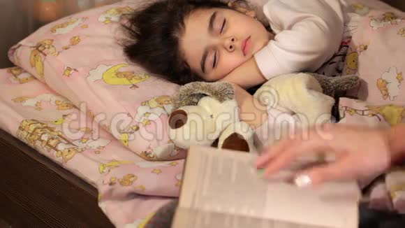 那个女人给女儿读了一晚上的书那个女孩在看书下睡着了童话故事的故事视频的预览图