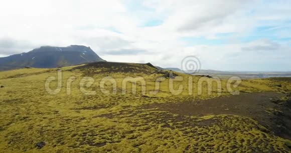 鸟瞰美丽的景观冰岛的绿色熔岩场无人机飞过长满青苔的悬崖视频的预览图