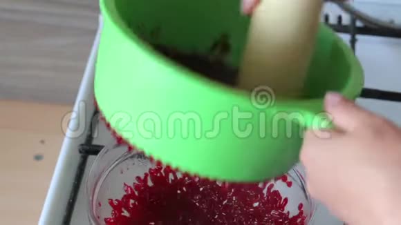一个女人把煮好的糖煮的蔓越莓用香菜揉搓为棉花糖准备土豆泥视频的预览图