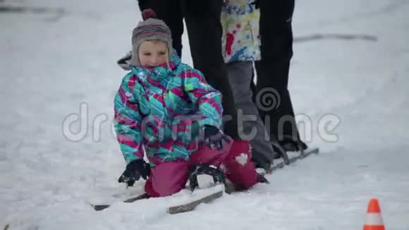 孩子站起来和家人一起走在木制滑雪板上视频的预览图