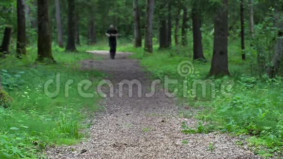 在靠近树的林间小道上跑累了的人视频的预览图