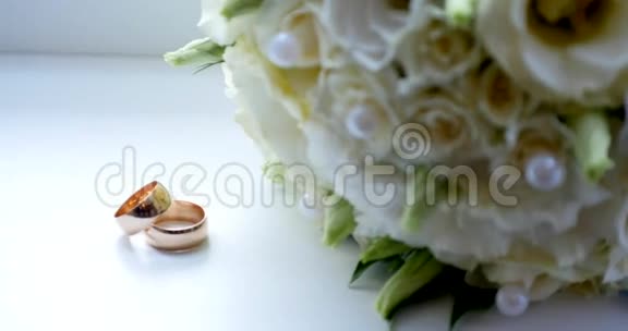把结婚戒指戴在白色玫瑰的老式木桌上视频的预览图