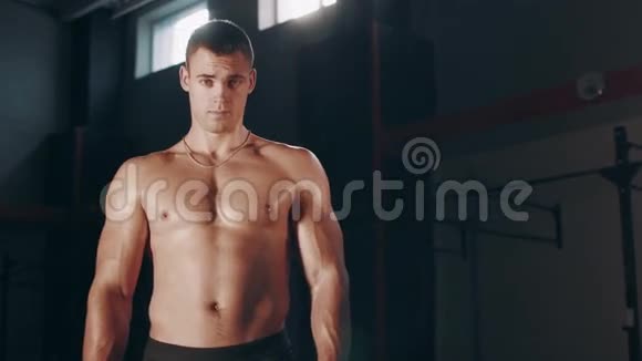 肌肉发达的帅哥站在大体育馆里视频的预览图