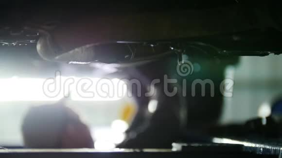 汽车服务机械师在提升的汽车离焦背景下工作时松开汽车部件视频的预览图