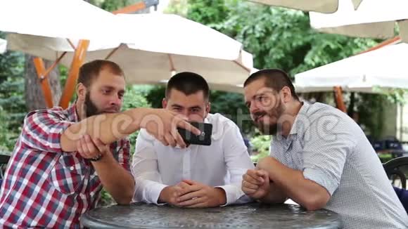 三个留着胡子的男人喝着淡啤酒说话视频的预览图