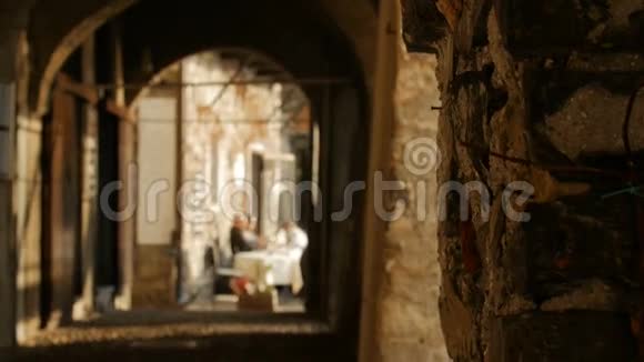 女人穿过历史建筑的拱门远离镜头视频的预览图