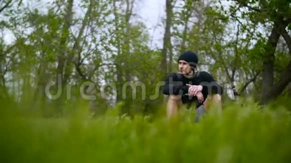 坐在森林草地上的年轻人视频的预览图