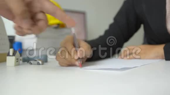 女人的手用红笔在白纸上画画男人的手指着白纸指着白纸的方向视频的预览图