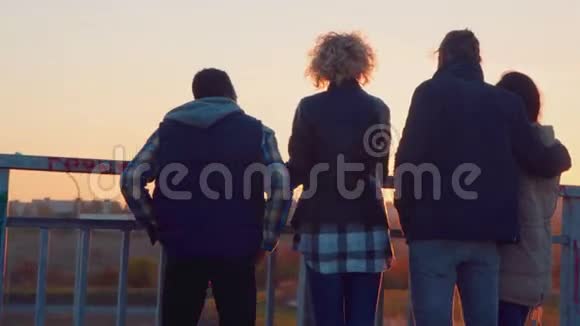 日落时分四个朋友在桥上闲逛视频的预览图
