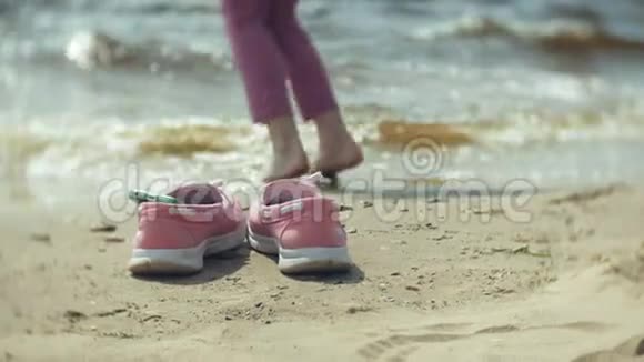 沙滩上的夏鞋在沙滩上散步跳舞的女孩视频的预览图
