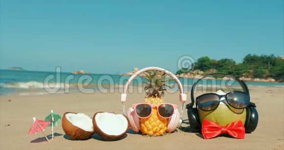 热带海滩上热带海岸菠萝和热带阳光下太阳眼镜上的水果视频的预览图