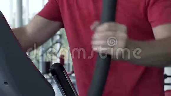 在健身房锻炼椭圆机的年轻人视频的预览图