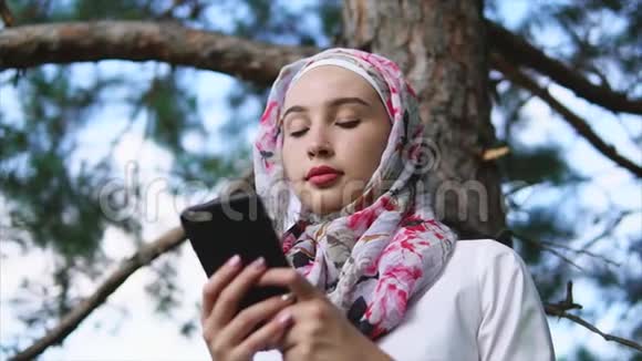 公园里的穆斯林女孩用手机视频的预览图