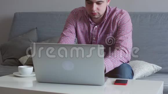 一个人在家工作使用顶部和轨迹板年轻的商人坐在桌子上喝咖啡做工作视频的预览图