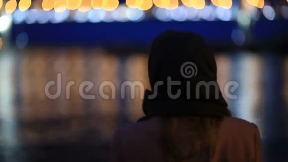 一对男女看着夜城夜晚城市的灯光在水面上闪烁斜拉视频的预览图