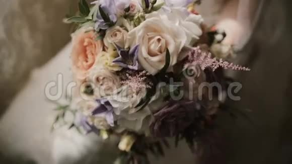 年轻漂亮的新娘捧着婚礼花束仪式前用鲜花特写女性视频的预览图
