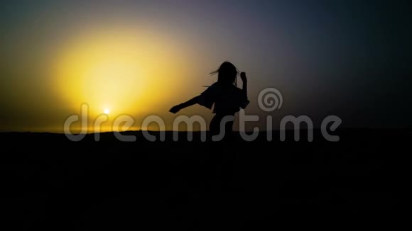 漂亮的女孩在沙漠里跳舞美丽的女人在日落时跳舞慢动作视频的预览图