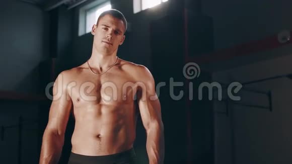肌肉发达的帅哥站在大体育馆里视频的预览图