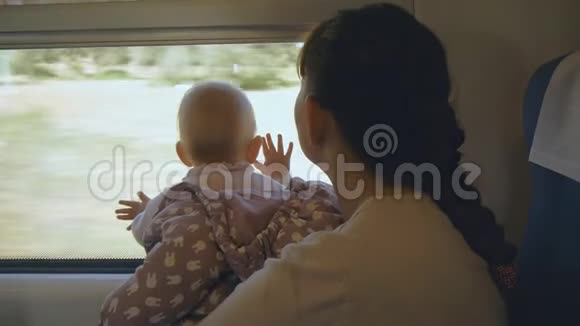 年轻的母亲抱着孩子坐火车旅行视频的预览图
