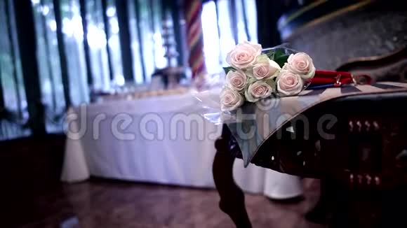 餐厅棕色木桌上的米色玫瑰花束视频的预览图