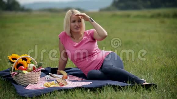 穿粉色衣服的女人四处张望躺在毯子上视频的预览图