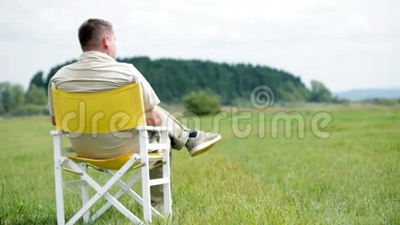 人们坐在白色的野餐椅上观察大自然给他带来的荣耀视频的预览图