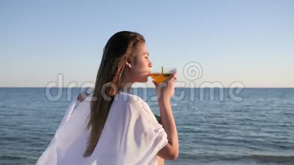 沙滩背光的性女孩年轻女性喝鸡尾酒视频的预览图