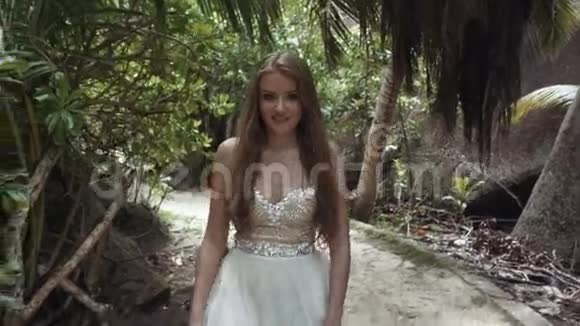 年轻的新娘穿着豪华礼服在热带海滩上放松视频的预览图