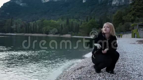 孤独的女人向大海扔石头视频的预览图