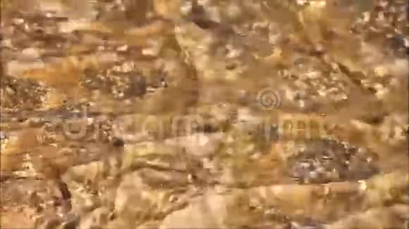 清澈的水流过棕色的岩石视频的预览图