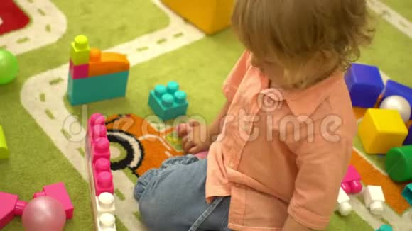 学龄前小女孩在幼儿园玩多种颜色的积木幼儿园的儿童发展视频的预览图