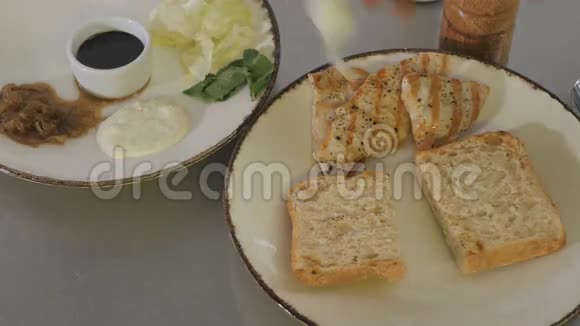 厨师准备了一个汉堡里面有面包切肯肉和绿色沙拉视频的预览图