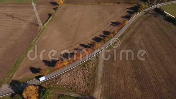 乡间小路穿过秋天的田野视频的预览图